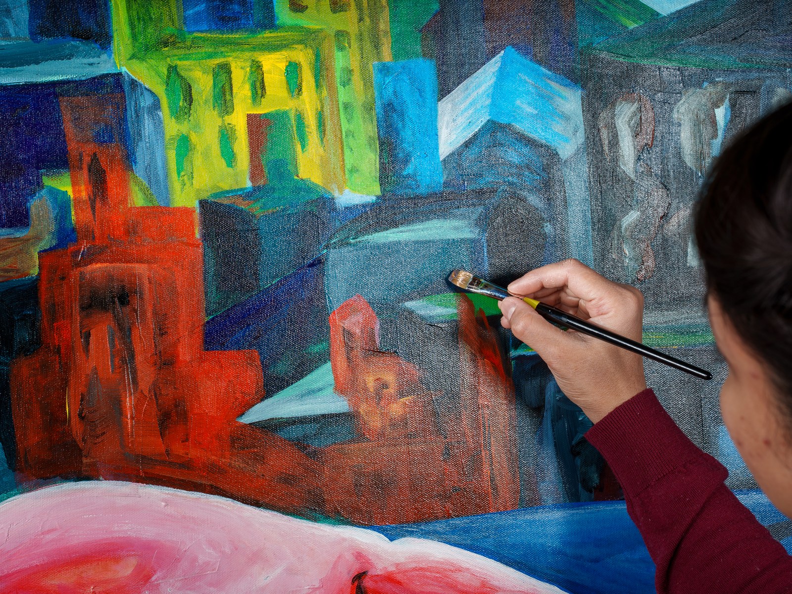 The artist's brush touches into the cityscape's blue-grey towers above the figure's pink shoulder. The Heat of Cold Distance, 2026, by Payal Agarwal.