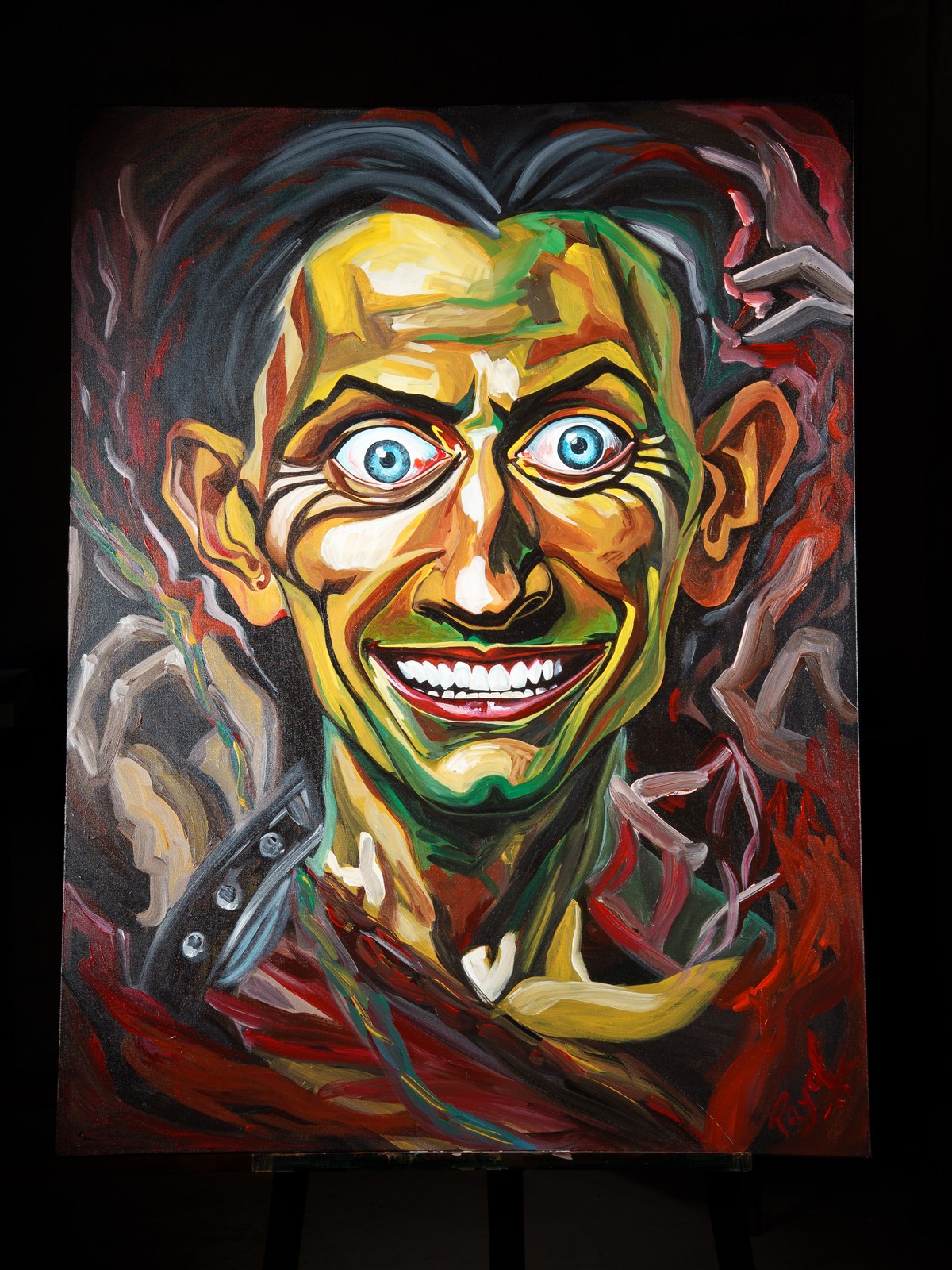 Full canvas on easel: jaundiced grin emerges from churning red and graphite shadow. The Insane Smile Longest, 2026, by Payal Agarwal.